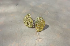 Par de aros colgantes de bronce y alpaca con diseño abstracto calado.