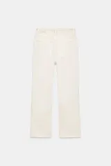 Jeans de tiro alto con cinco bolsillos, diseño cropped flare y bajo sin costuras. Cuenta con cierre frontal de cremallera y botón metálico.
