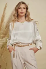 Blusa de satén color champagne con cuello a la base, mangas anchas y puños elásticos con detalle bordado.