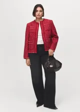 Chaqueta de tweed color rojo, de diseño recto, cuello redondo y manga larga. Cuenta con terminaciones deshilachadas y cuatro bolsillos de parche delanteros.
