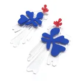 Aros colgantes con forma abstracta, con pieza superior roja, pieza central azul y pieza inferior transparente.