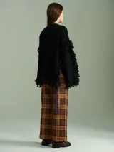 Sweater azul con bordado central en forma de trenza, detalles laterales a cuadros y terminaciones desflecadas. Tiene corte oversize, cuello redondo y tajos laterales con cordones.