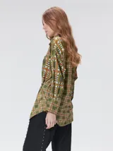 Camisa de seda con estampado geométrico de cuadrados en tonos rojizos y marrones. Presenta cuello camisero, cierre frontal con botones, bolsillo en el pecho y mangas largas con puños abotonados.