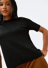 Blusa color beige de tejido de punto, con cuello redondo y mangas cortas.