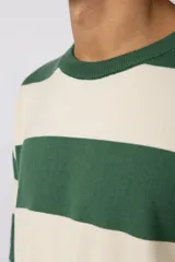 Remera de tejido de punto con diseño de rayas horizontales anchas en color bordó y crema, de corte holgado y cuello redondo.