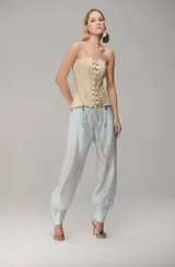 Pantalón de organza translúcida en color celeste, de corte amplio con efecto abullonado, pliegues frontales y puños ajustados en los tobillos con cierre lateral.