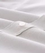 Camisa de vestir para hombre, de manga larga y calce clásico, confeccionada en tricolina de algodón y poliéster, con diseño de cuadros grid en tono celeste claro. Presenta cuello camisero, cierre frontal con botones y puños ajustables con botón único.