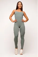 Jumpsuit deportivo de una pieza, color verde militar, con breteles finos y diseño ajustado al cuerpo. Presenta un corte estratégico que realza la figura y espalda escotada.