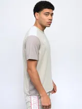 Remera deportiva Umbro de corte clásico, color gris con mangas cortas blancas y logo de la marca en el pecho.