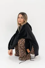 Buzo canguro negro de tejido suave, con capucha y bolsillo canguro frontal. Presenta puños y cintura elásticos.