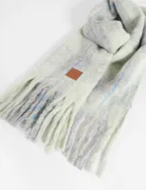 Bufanda larga de tejido grueso con diseño a cuadros en tonos gris, blanco y celeste.