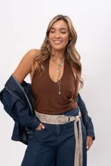 Faja de cuero gamuzado metalizado color visón, con curvatura anatómica, herraje metálico plateado y tiras largas con flecos para atar en nudo.