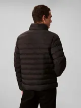Campera puffer de peso medio Calvin Klein, color negro, con diseño acolchado, cuello alto y cierre frontal de cremallera. Presenta el logo de la marca estampado en el pecho.