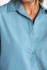 Camisa celeste con rayas verticales blancas, de corte oversize y manga larga.