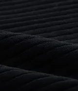 Blusa negra de punto liviano con textura acanalada, escote en pico y mangas largas.