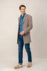 Chaquetón de lana color beige, con solapas clásicas, cierre frontal de botones y bolsillo en el pecho con pañuelo decorativo.
