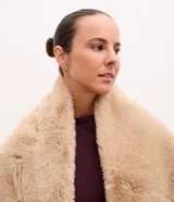 Bufanda de pelo sintético en color beige, con textura suave y voluminosa, ideal para climas fríos.