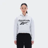 Canguro Reebok de corte crop color gris melange, con capucha ajustable con cordones, mangas largas y el logotipo de la marca estampado en el pecho en color negro.