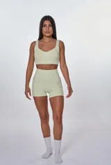 Conjunto deportivo compuesto por un top de escote redondo con logo estampado y un short de tiro alto con diseño ajustado.