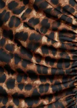 Vestido largo de tejido fluido con estampado de leopardo, cuello redondo y mangas cortas. Presenta un diseño entallado con detalles fruncidos en los laterales.