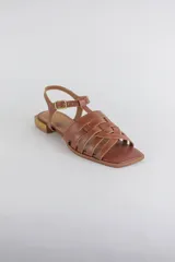 Sandalias de cuero color negro, de suela plana, con tiras entrelazadas en la capellada y tira ajustable en el talón con hebilla metálica.