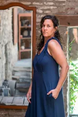 Vestido largo azul marino de lycra de algodón, con corte amplio, escote redondo al frente y escote profundo en la espalda. Tiene breteles con lazos ajustables, bolsillos y tajos laterales.