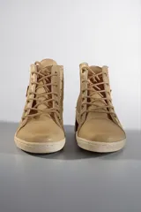 Botas de caña alta de cuero vacuno en color beige con brillos suaves y detalles pintados a mano por Carolina De Cunto, con cordones y suela de goma.