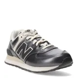 Championes urbanos New Balance modelo 574, color gris oscuro metalizado con detalles en beige claro. Presentan el logo 'N' en negro con borde blanco y cordones beige.