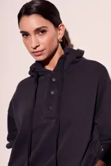 Sweater con capucha color negro, con cordones ajustables y botones en el escote.