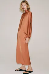 Vestido tipo túnica de viscosa color terracota, con cuello redondo, mangas largas amplias y diseño midi.