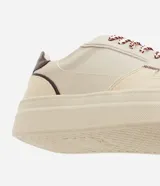 Championes casuales Satinato de diseño urbano, confeccionados en poliuretano con recortes superpuestos y costuras visibles. Presentan puntera redondeada con microperforaciones, suela alta de goma, refuerzo trasero en color contrastante y cordones con diseño diferenciado.