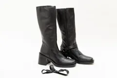 Bota de caña alta color negro, de cuero, con punta cuadrada y taco cuadrado. Incluye estribo desmontable.