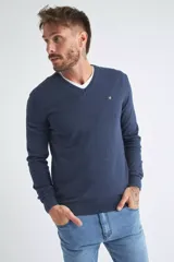 Sweater de tejido de punto color beige, con escote en V, mangas largas y puños y dobladillo acanalados. Presenta un pequeño logo bordado en el pecho.