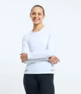 Remera deportiva femenina de manga larga y cuello redondo, confeccionada en tejido de poliamida texturizado con detalle reflectivo en el bajo.