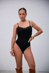 Body ajustado negro con tirantes finos y detalle de encaje en el escote.