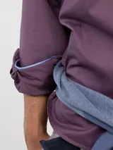 Camisa de hombre color azul, con cuello buttondown, cierre frontal con botones y logo bordado en el pecho. Presenta un acabado vintage logrado mediante el proceso de teñido en prenda.