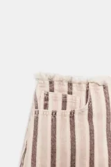 Shorts de denim de tiro bajo con diseño de rayas verticales en tonos rosado y marrón, cinco bolsillos, cierre frontal con cremallera y botón, y detalle de cintura desflecada.