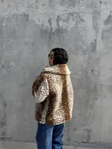 Campera de piel sintética con estampado animal print de leopardo, diseño de corte holgado, cuello solapa y textura suave.