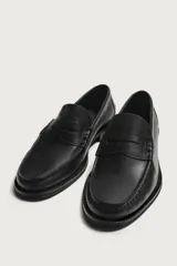 Mocasín de vestir para hombre fabricado en piel de color marrón oscuro, con detalle de antifaz en el empeine y suela con ligero tacón.