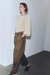 Pantalón cargo de tiro medio en color marrón, confeccionado con mezcla de lana. Presenta cintura con detalle de vuelta, pliegues frontales, bolsillos laterales y bolsillos con solapa en las piernas. Cierre frontal con cremallera, botón y ganchos metálicos.