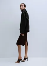 Blusa de mezclilla negra con costuras en contraste, cuello alto y solapa trasera.