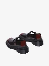 Zapato tipo Mary Jane color bordó brillante con efecto de dos tonos, suela gruesa acanalada negra y tacón cuadrado. Cuenta con una correa ajustable con hebilla sobre el empeine.