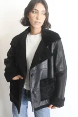 Campera de napalán de cuero genuino color negro, con interior y detalles de piel sintética en cuello, puños y bolsillos frontales. Diseño de corte recto con cierre de botones.