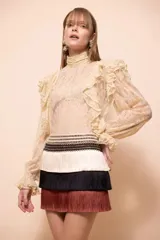 Falda corta de Patbo modelo Rita Fringe, diseño de tres niveles con flecos en tonos beige, negro y marrón, y cintura con detalles tejidos.