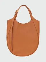 Bolso tote de gran tamaño Longchamp modelo Le Foulonné, confeccionado en cuero negro con textura granulada. Presenta una silueta estructurada con base redondeada, doble asa de hombro y herrajes metálicos en tono plateado.