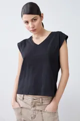 Remera color pistacho con cuello en V y botones decorativos en los hombros.
