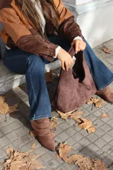 Cartera tipo hobo de gamuza negra, con diseño minimalista y asa integrada.