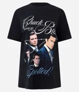 Remera negra de algodón con cuello redondo y mangas cortas. Presenta un estampado gráfico frontal con imágenes de Chuck Bass de la serie Gossip Girl y lettering decorativo.