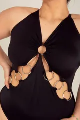 Body colaless negro de LYCRA® con breteles elásticos regulables cruzados en la espalda y detalle de aros metálicos en el frente. Tiene broche en la entrepierna con fundillo de algodón 100%.