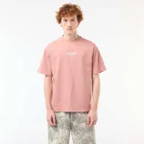 Remera rosada de corte oversize con cuello redondo, manga corta y pequeño bordado frontal con el texto "True Self".